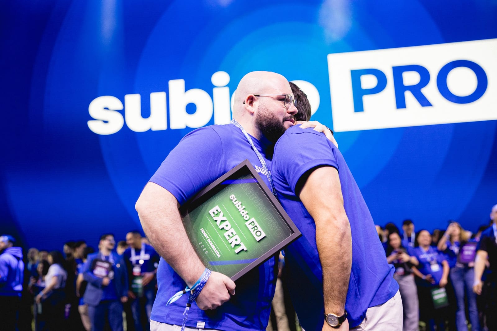 Henry Bombarda e Pedro Sobral se abraçando no palco do SubidoPRO, com o certificado Expert na mão